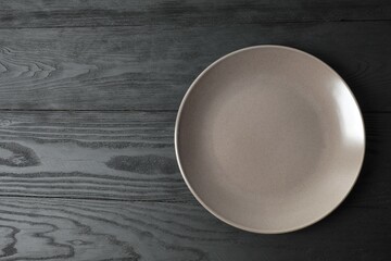 Empty round plate on wooden background, top view