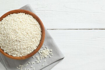 Healthy eating. Wooden bowl with uncooked rice on a wooden background
