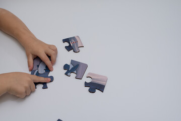 children's hands putting together a puzzle