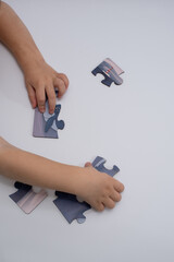 children's hands putting together a puzzle