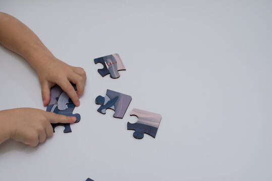 children's hands putting together a puzzle
