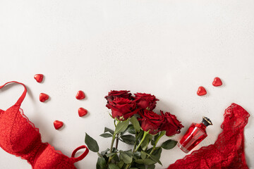 Valentine's day frame with red lace bustier underwear, candy sweets and red roses on white...
