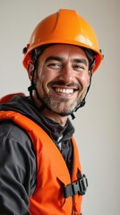 Fototapeta premium Smiling male construction worker wearing an orange hard hat and safety vest