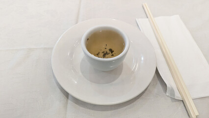 Photo of green tea place setting with chopsticks, napkin, and tableware tradition, hospitality, celebration, Chinese culture. Concept of Chinese new year, lunar year, dim sum, green tea, dining.