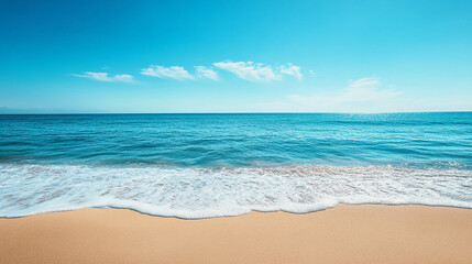 Clear blue ocean waves gently lapping on a sandy beach under a bright sky