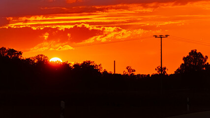 Sunset with a chimney and a powerline silhouette near Moos, Deggendorf, Bavaria, Germany