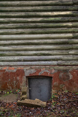 Rustic log cabin wall with aged wood and peeling paint