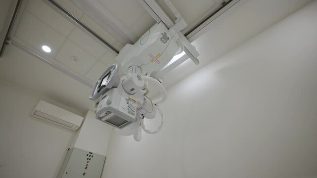 Close-up of a modern X-ray machine mounted on a ceiling in a hospital. Concept of advanced medical technology and healthcare infrastructure in diagnostic imaging