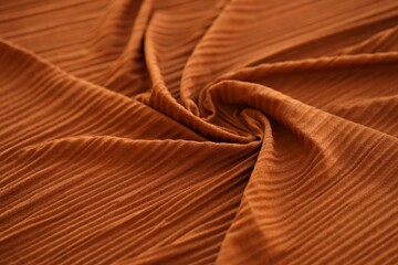 Bright orange fabric background from a piece of crumpled clothes