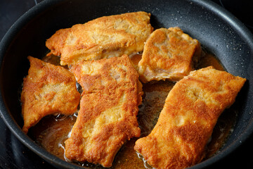 Frying breaded carp fish on cooking pan