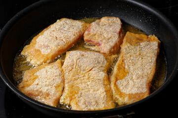 Frying breaded carp fish on cooking pan