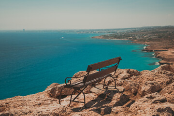 Bench on a Cliff Overlooking the Blue Coastline