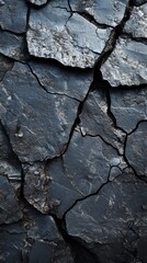 Fototapeta premium Rugged black coal surface with deep cracks and textured details