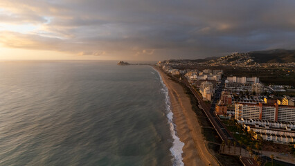 Drone aerial view of a beach in a coudy day in Peniscola