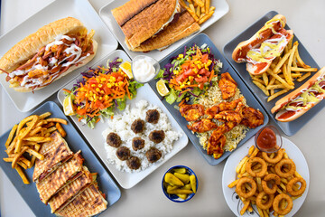 Delicious meat kebab with fresh vegetable salad served with variety of Turkish dishes and appetizers. Top view of assorted Turkish food and meze, tasty and healthy Mediterranean cuisine.