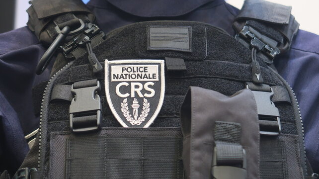 "Police nationale &ndash; CRS" (Compagnies R&eacute;publicaines de S&eacute;curit&eacute;) inscrit sur un &eacute;cusson brod&eacute;, avec un logo, sur le gilet pare-balles d&rsquo;un policier fran&ccedil;ais &ndash; juin 2024 (France)