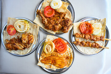 Delicious meat kebab with fresh vegetable salad served with variety of Turkish dishes and appetizers. Top view of assorted Turkish food and meze, tasty and healthy Mediterranean cuisine.