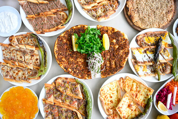 Traditional Turkish cuisine. Pizza, pita, pidesi, sucuk, hummus, kebab. Many dishes on the table. Serving dishes in restaurant. Margherita,  mix, formaggi, veggie karisik pizza. Top view, flat lay