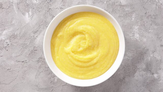 creamy polenta in bowl on light surface rotation food