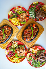 Delicious meat kebab with fresh vegetable salad served with variety of Turkish dishes and appetizers. Top view of assorted Turkish food and meze, tasty and healthy Mediterranean cuisine.