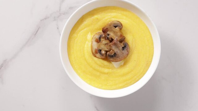 creamy polenta with mushrooms in bowl on light surface food