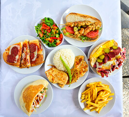 Delicious meat kebab with fresh vegetable salad served with variety of Turkish dishes and appetizers. Top view of assorted Turkish food and meze, tasty and healthy Mediterranean cuisine.