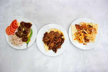 Delicious meat kebab with fresh vegetable salad served with variety of Turkish dishes and appetizers. Top view of assorted Turkish food and meze, tasty and healthy Mediterranean cuisine.