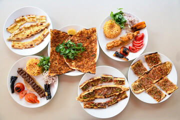 Delicious meat kebab with fresh vegetable salad served with variety of Turkish dishes and appetizers. Top view of assorted Turkish food and meze, tasty and healthy Mediterranean cuisine.