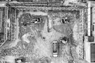 Heavy construction equipment working at the construction site. Aerial view from drone