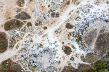 aerial photograph of a rocky landscape. The terrain have a areas with sparse vegetation.