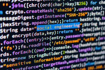Social engineering. Image shows a close-up of C code highlighting social engineering, situated in a workspace on a laptop screen The code is structured and vibrant with varying shades of blue, purple