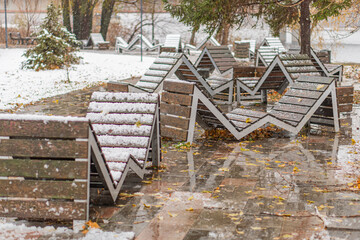 Outdoor seating area covered with snow and possibly ice during winter, reflecting a mix of precipitation types and emptiness