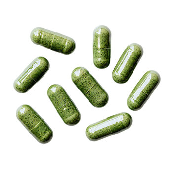 Several green pills placed on a plain white background, perfect for showcasing their sleek design and wellness-focused qualities