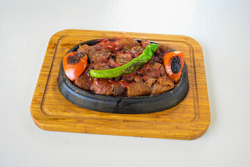 Turkish  Traditional Ramadan doner kebab with tasty tomato sauce and rice or turkish pilav in white plate on table background. Lavash doner kebab ( doner zurna durum )  Pilavustu doner Iskender kebap