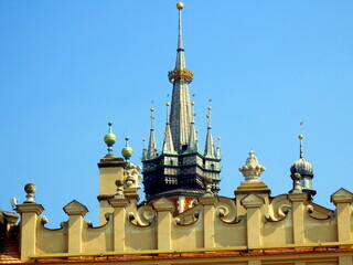 The two towers of Saint Mary's Basilica as seen behind the parapet of Cloth Hall in Main Square,...