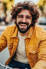 Fototapeta premium Smiling Young Man with Beard and Glasses in Stylish Yellow Jacket Outdoors