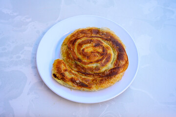 Turkish style meat stuffed filo dough borek served kol boregi.Cheese and minced pie are sliced on a marble background. Turkish name: Kol Boregi, kiymali, peynirli su boregi. Ci borek. Kafkas cig borek