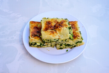 Turkish style meat stuffed filo dough borek served kol boregi.Cheese and minced pie are sliced on a marble background. Turkish name: Kol Boregi, kiymali, peynirli su boregi. Ci borek. Kafkas cig borek