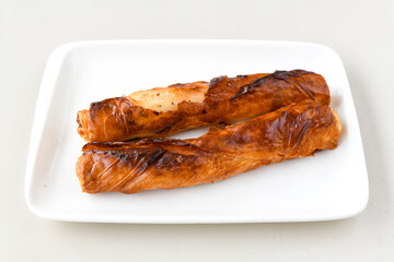 Turkish style meat stuffed filo dough borek served kol boregi.Cheese and minced pie are sliced on a marble background. Turkish name: Kol Boregi, kiymali, peynirli su boregi. Ci borek. Kafkas cig borek