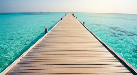 Obraz premium Tranquil turquoise water meets a wooden pier. Tropical beach vacation paradise. Calm blue ocean.