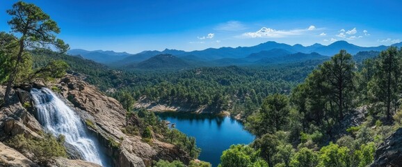 Panoramic view of waterfall cascading into a serene mountain lake, surrounded by lush greenery and majestic mountains under a vibrant blue sky.