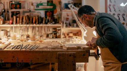 Italian violin maker crafting violin in cremona workshop