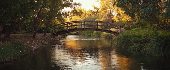 Fototapeta premium Wooden bridge over calm river in autumnal park.