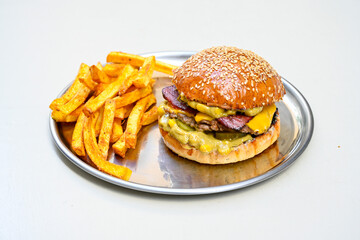 Big tasty burger with beef cutlet on a plate. Hamburger, cheeseburger with mushroom. Hamburger, Mexica, mushroom double burger.  Crispy chicken burger. With french fries, patates kizartmasi.
