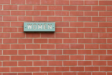 Obraz premium women sign on red brick wall