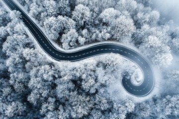 Foggy winter road with a winding asphalt path disappearing into the mist.