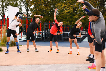 Group of people exercising and stretching outdoors
