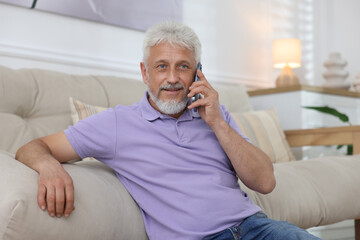 Senior man talking on phone at home