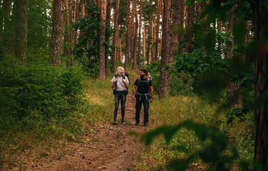 Obraz premium family with a small child in a travel backpack baby carrier. go camping with a tent and backpacks