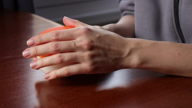 White European Girl Applying Hand Cream. Copy Space Close Up